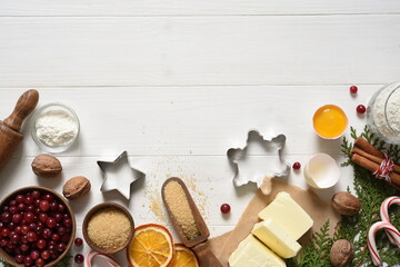 Ingredients for Christmas baking on a wooden white background. Christmas cookie recipe. Food preparation products: eggs, butter, flour, sugar.