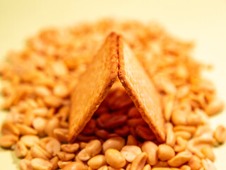 Appetizing brown dry cracker on scattered roasted peanuts