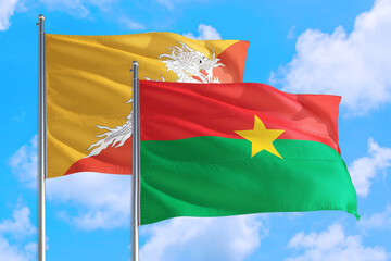 Burkina Faso and Bhutan national flag waving in the windy deep blue sky. Diplomacy and international relations concept.