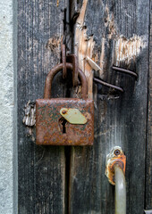 old rusty padlock on a shabby wooden door