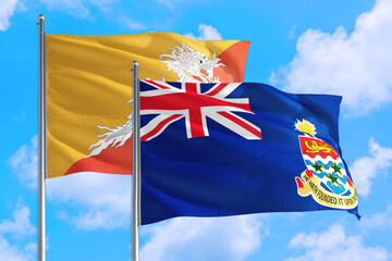 Cayman Islands and Bhutan national flag waving in the windy deep blue sky. Diplomacy and international relations concept.