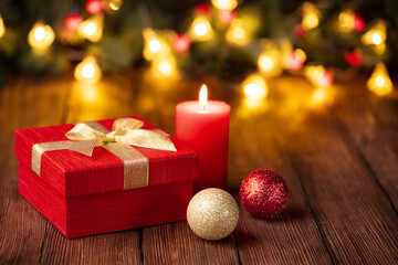 Fototapeta na wymiar Christmas still life with candle and gift box on wooden table