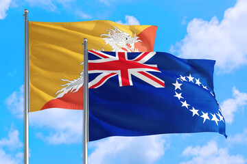 Cook Islands and Bhutan national flag waving in the windy deep blue sky. Diplomacy and international relations concept.