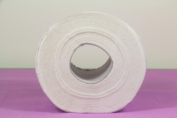 White toilet paper roll on purple background
