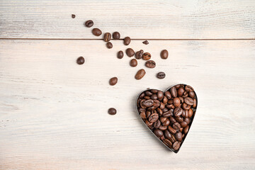 Coffee heart on a light background. A flying heart with a tail of scattered grains. Coffee background. Concept of holidays, February 14, March 8, love of coffee.