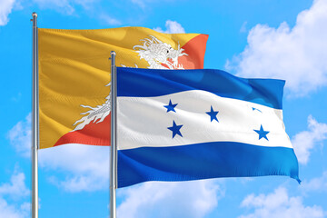 Honduras and Bhutan national flag waving in the windy deep blue sky. Diplomacy and international relations concept.