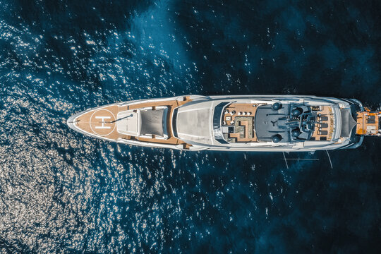Aerial view of yacht in blue sea with helipad, Saint Tropez, France.