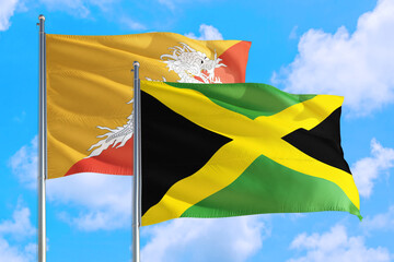 Jamaica and Bhutan national flag waving in the windy deep blue sky. Diplomacy and international relations concept.