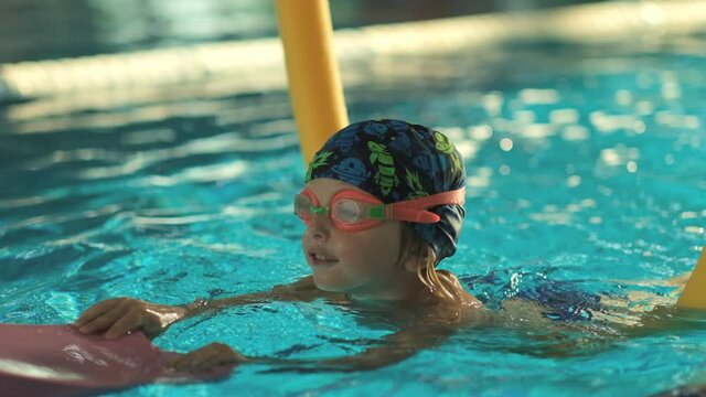 Future champion. Swimming training for the little champion. Little cute boy strengthens his health by swimming in the pool.