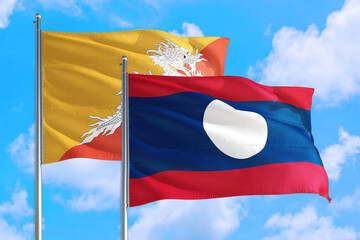 Laos and Bhutan national flag waving in the windy deep blue sky. Diplomacy and international relations concept.