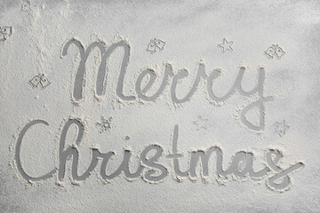 Different drawings and phrase Merry Christmas made of flour on grey table, top view