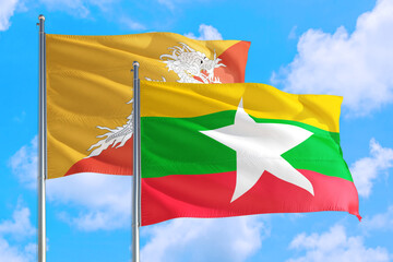 Myanmar and Bhutan national flag waving in the windy deep blue sky. Diplomacy and international relations concept.