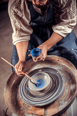 Handicraftsman master working on potter's wheel with raw clay with hands. Handcraft. Close-up.