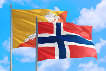 Norway and Bhutan national flag waving in the windy deep blue sky. Diplomacy and international relations concept.