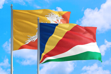 Seychelles and Bhutan national flag waving in the windy deep blue sky. Diplomacy and international relations concept.