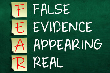 Motivating and inspiring FEAR acronym on sticky notes posted to chalkboard meaning False Evidence Appearing Real. - obrazy, fototapety, plakaty