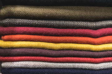 close up of colorful fabric,  a pile of cashmere textile, stack of colorful clothes, pile of...