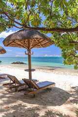 Beautiful beach of Mauritius island,view with torquise sea ,palm trees and umbrella.