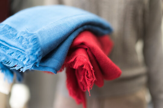 Close Up Of Colorful Scarf, Close Up Blue And Red Cashmere Textile Clothes, Woollen Piece Of Fabric,  Soft Focus, Blurred Bokeh On A Grey Background