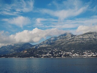 Seascape overlooking the mountains with cumulus clouds hanging overhead