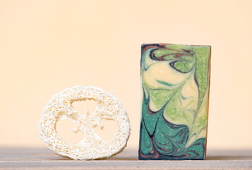 Handmade hemp soap and loofah sponges on a beige background. Eco lifestyle concept...