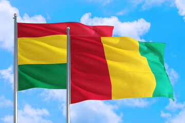 Guinea Bissau and Bolivia national flag waving in the windy deep blue sky. Diplomacy and international relations concept.