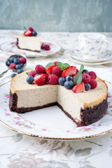 Traditional American New York cheesecake with fruits offered as close-up on design plate