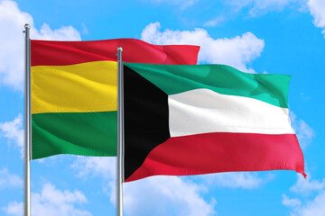 Kuwait and Bolivia national flag waving in the windy deep blue sky. Diplomacy and international relations concept.