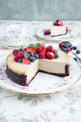 Traditional American New York cheesecake with fruits offered as close-up on design plate