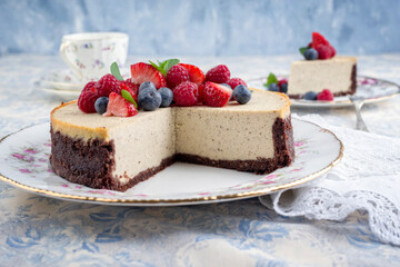 Traditional American New York cheesecake with fruits offered as close-up on design plate