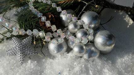 beautiful silver star and balls and fairy lights holiday decoration on snow with copy space