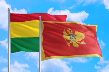 Montenegro and Bolivia national flag waving in the windy deep blue sky. Diplomacy and international relations concept.