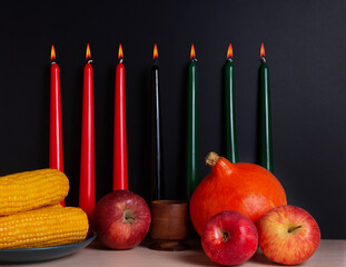 Kwanzaa banner with candles on light background and copy space on the right. Afro-American holiday. Seven candles as symbol of principles of African Heritage. 