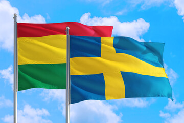 Sweden and Bolivia national flag waving in the windy deep blue sky. Diplomacy and international relations concept.