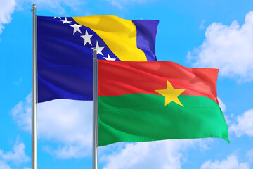 Burkina Faso and Bosnia Herzegovina national flag waving in the windy deep blue sky. Diplomacy and international relations concept.