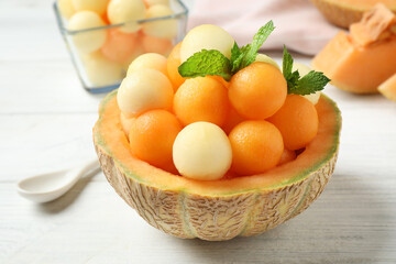 Different melon balls with mint on white wooden table