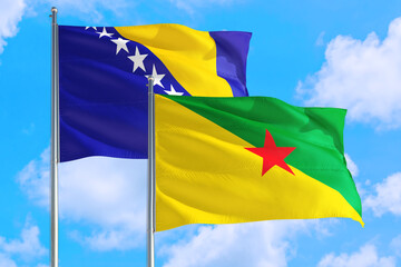 French Guiana and Bosnia Herzegovina national flag waving in the windy deep blue sky. Diplomacy and international relations concept.