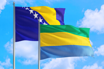 Gabon and Bosnia Herzegovina national flag waving in the windy deep blue sky. Diplomacy and...