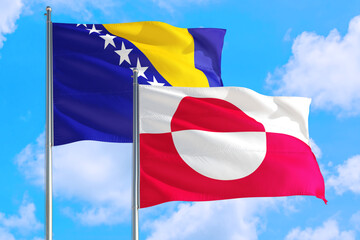 Greenland and Bosnia Herzegovina national flag waving in the windy deep blue sky. Diplomacy and international relations concept.