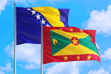 Grenada and Bosnia Herzegovina national flag waving in the windy deep blue sky. Diplomacy and...