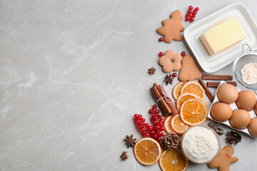 Flat lay composition with homemade Christmas cookies and ingredients on grey table, space for text