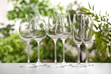 Set of clean glasses on grey table against blurred background