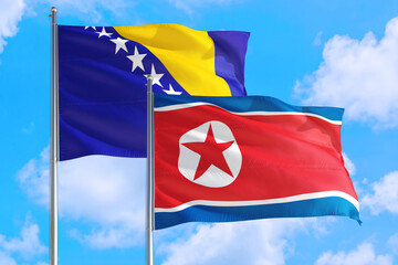 Naklejka premium North Korea and Bosnia Herzegovina national flag waving in the windy deep blue sky. Diplomacy and international relations concept.