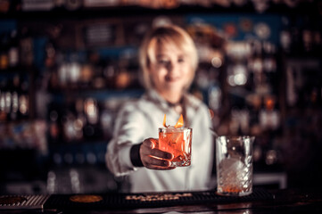 Girl bartender makes a cocktail in the beerhall