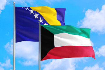 Kuwait and Bosnia Herzegovina national flag waving in the windy deep blue sky. Diplomacy and international relations concept.