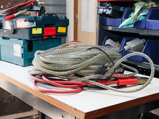 hose on the table.
White plastic and red hoses with tool boxes lie on a white shelf in a workshop, close-up side view.