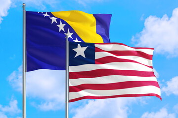 Liberia and Bosnia Herzegovina national flag waving in the windy deep blue sky. Diplomacy and international relations concept.