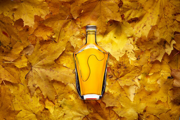 Brandy bottle on yellow maple leaves