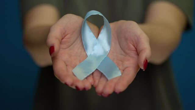 World diabetes day. Blue ribbon symbolic isolated with hand support