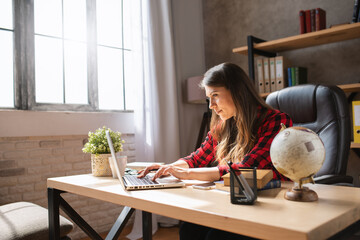 Girl teleworker works at home with a laptop. She is in smart working due to covid-19 pandemic